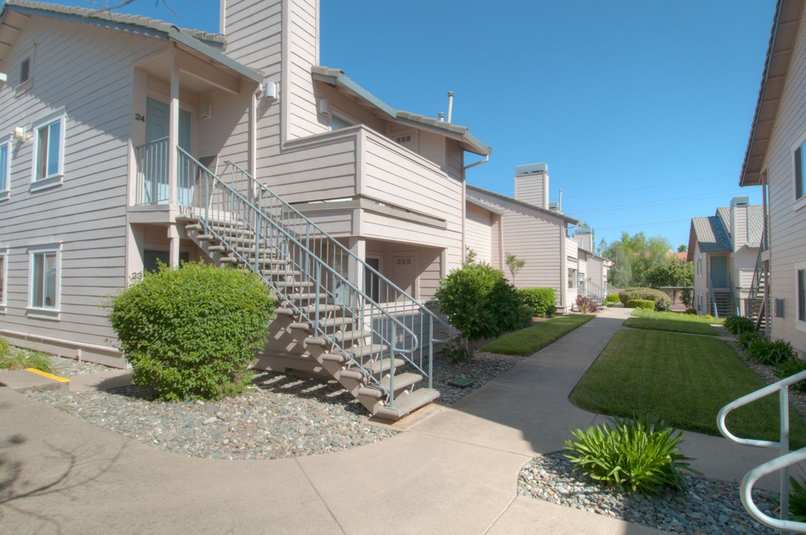 A view of the sidewalk in between apartment buildings