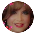 Close-up circular portrait of a smiling person with curly brown hair and red lipstick, with pink heart accents.