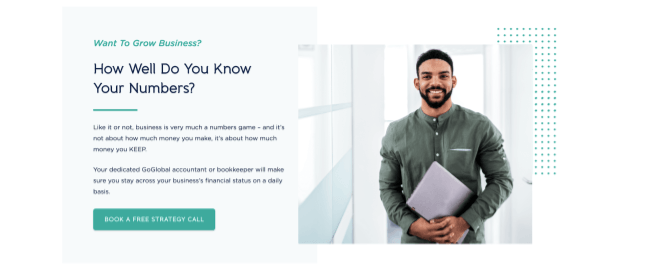 A man with a beard is holding a laptop and a piece of paper.
