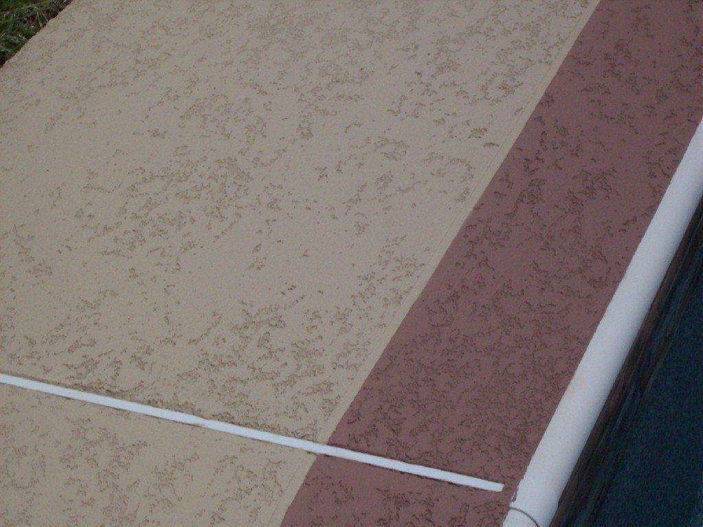 Beige and brown textured concrete poolside with white border.