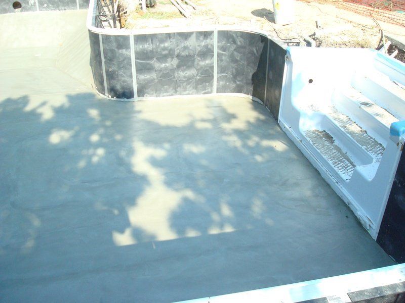 Newly plastered swimming pool interior with stairs.