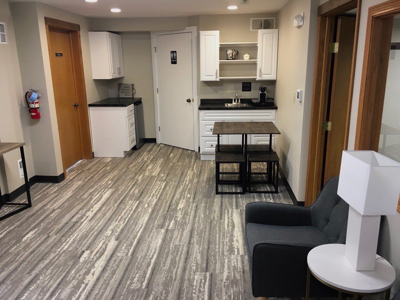 Small studio apartment with kitchenette, seating area, and wood-look flooring.