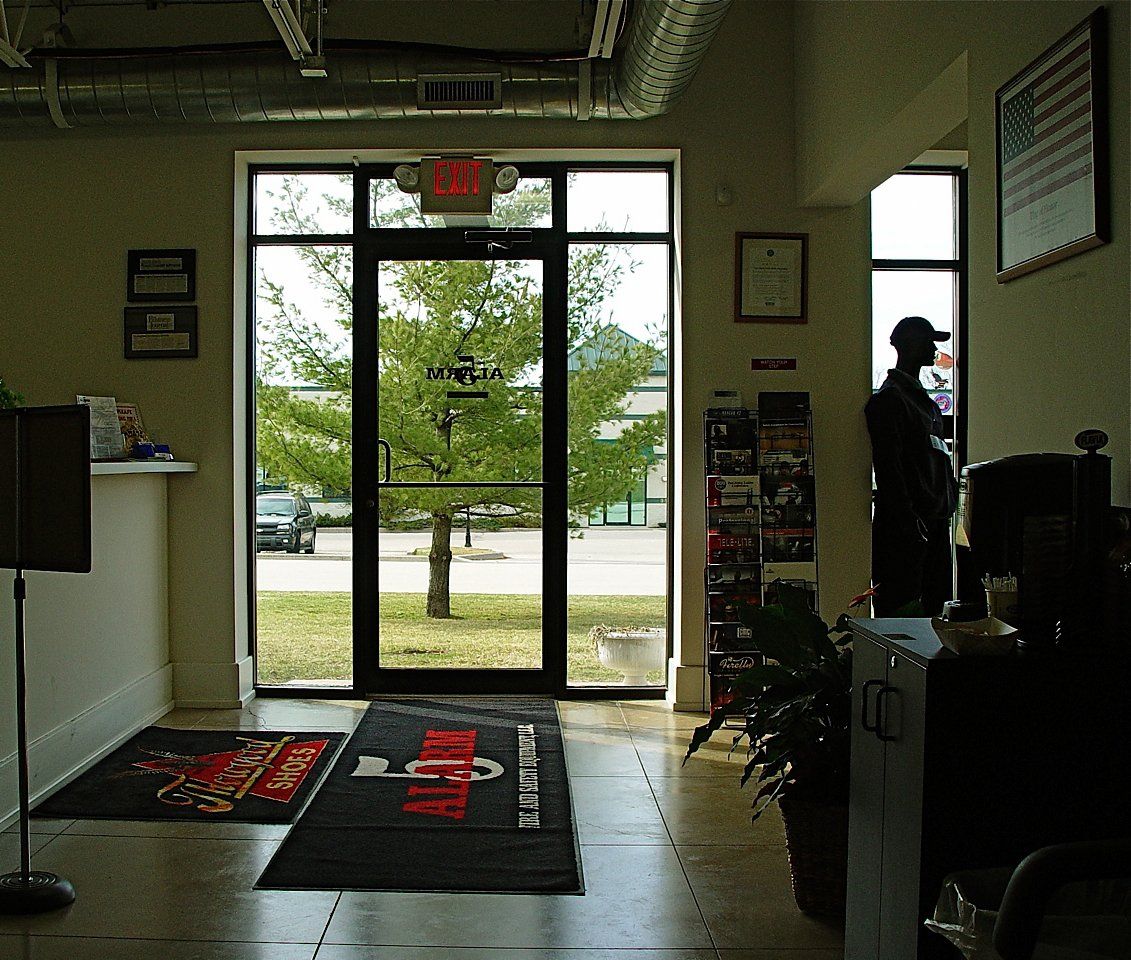 Interior doorway with a view of a tree. A person stands near a counter, and an American flag hangs on the wall.
