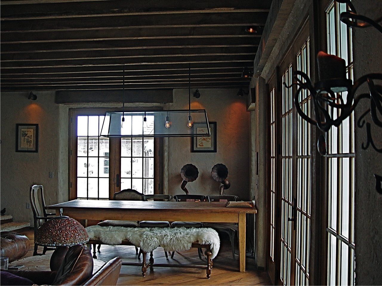 Interior view of a dining area with wooden table, windows, and antique record players.