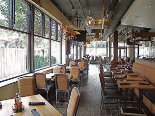 Restaurant interior with large windows, tables, chairs, and decorative airplane models.