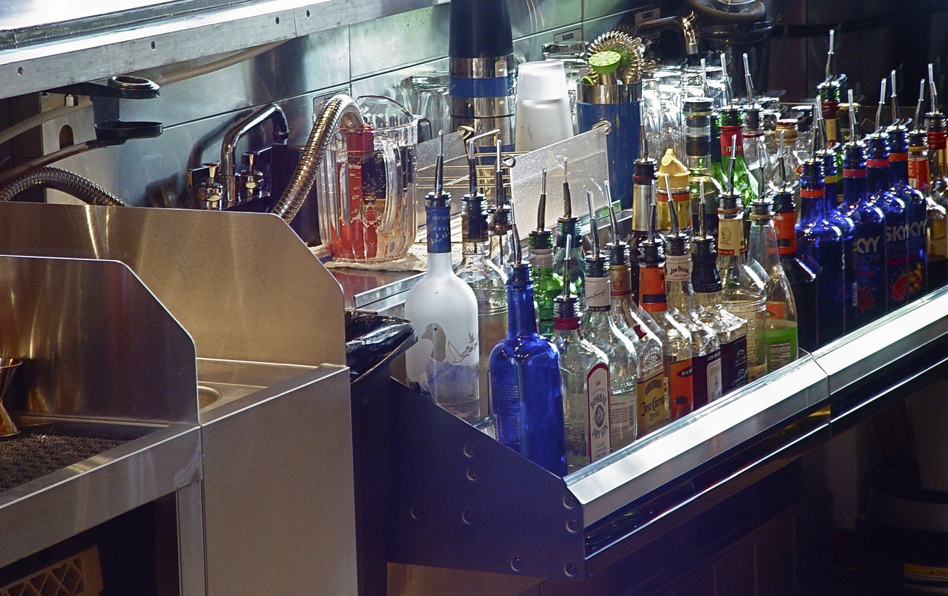 Bar with bottles of liquor and mixing equipment.