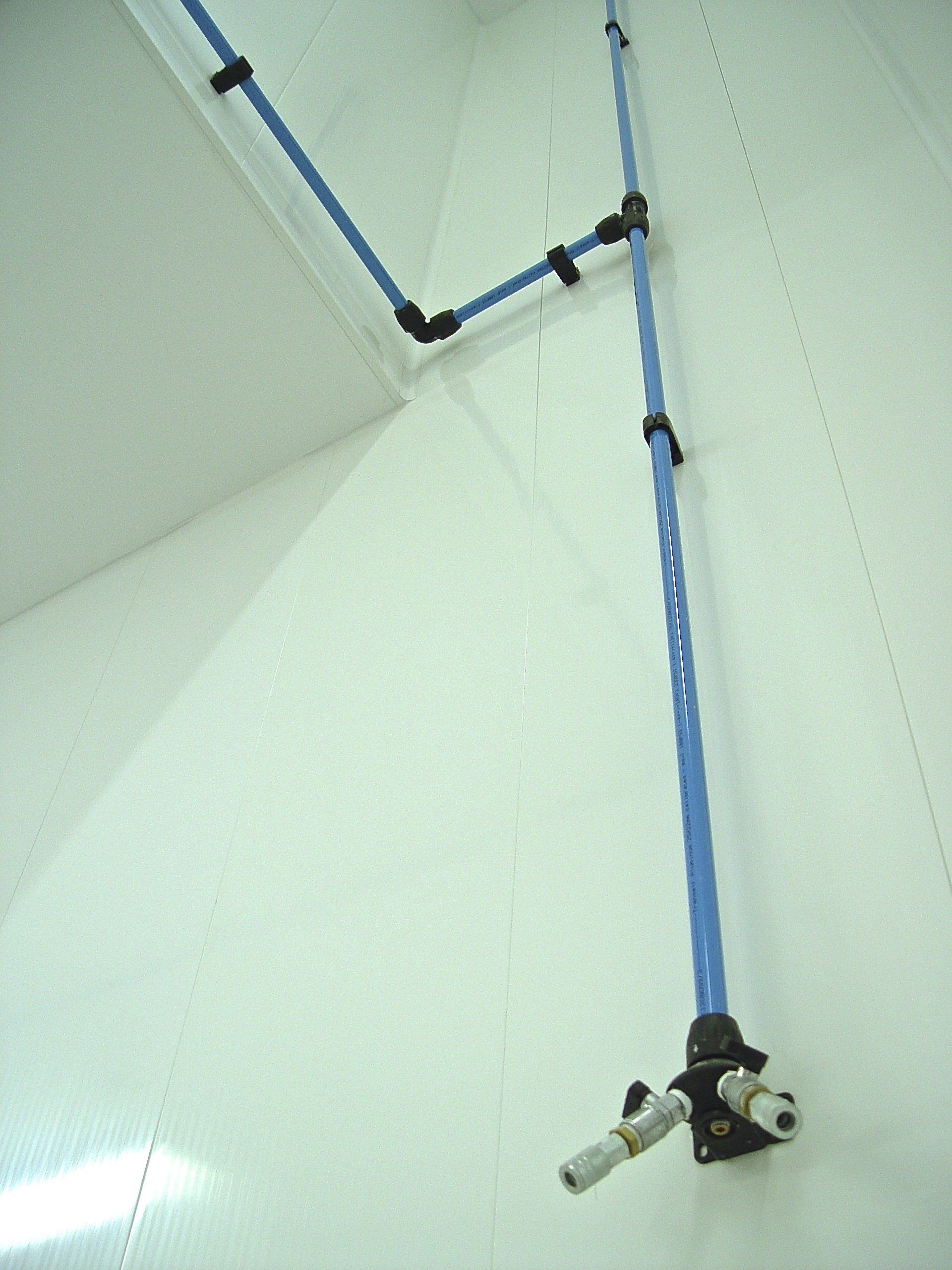 Blue air piping system mounted on a white wall.