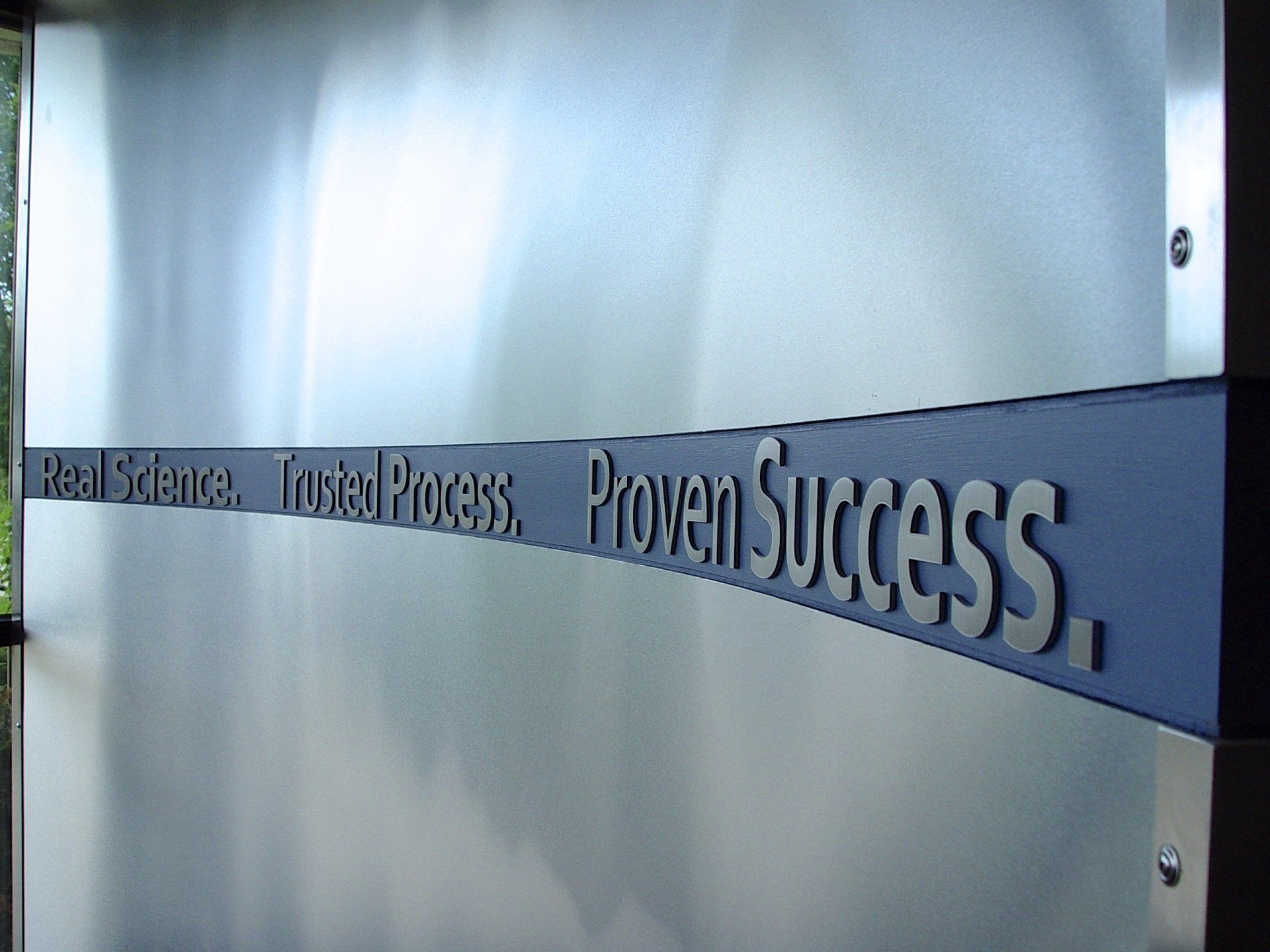 Silver metal wall with a dark blue banner reading 