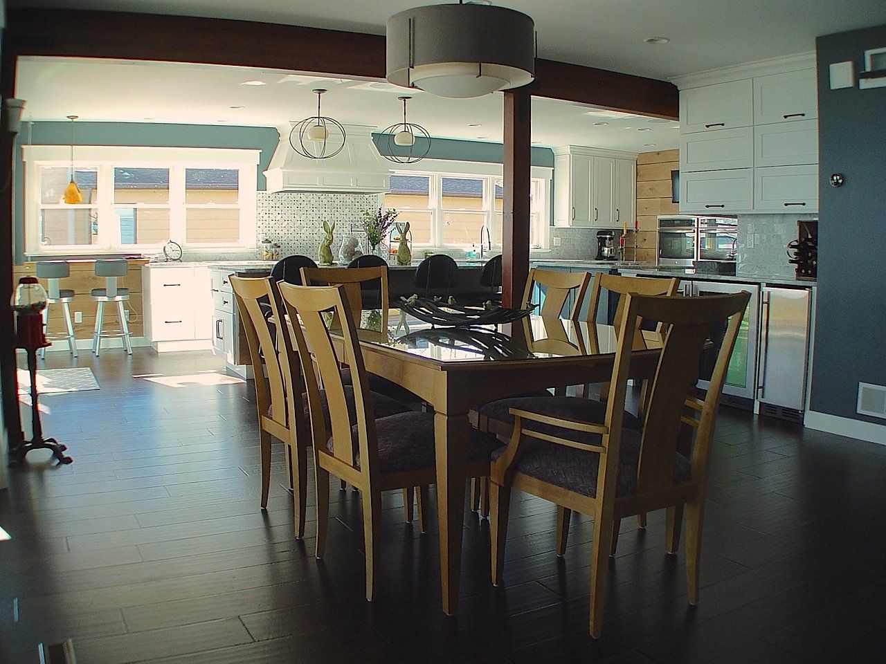 Dining area with wooden table and chairs, adjacent to a kitchen with white cabinets.