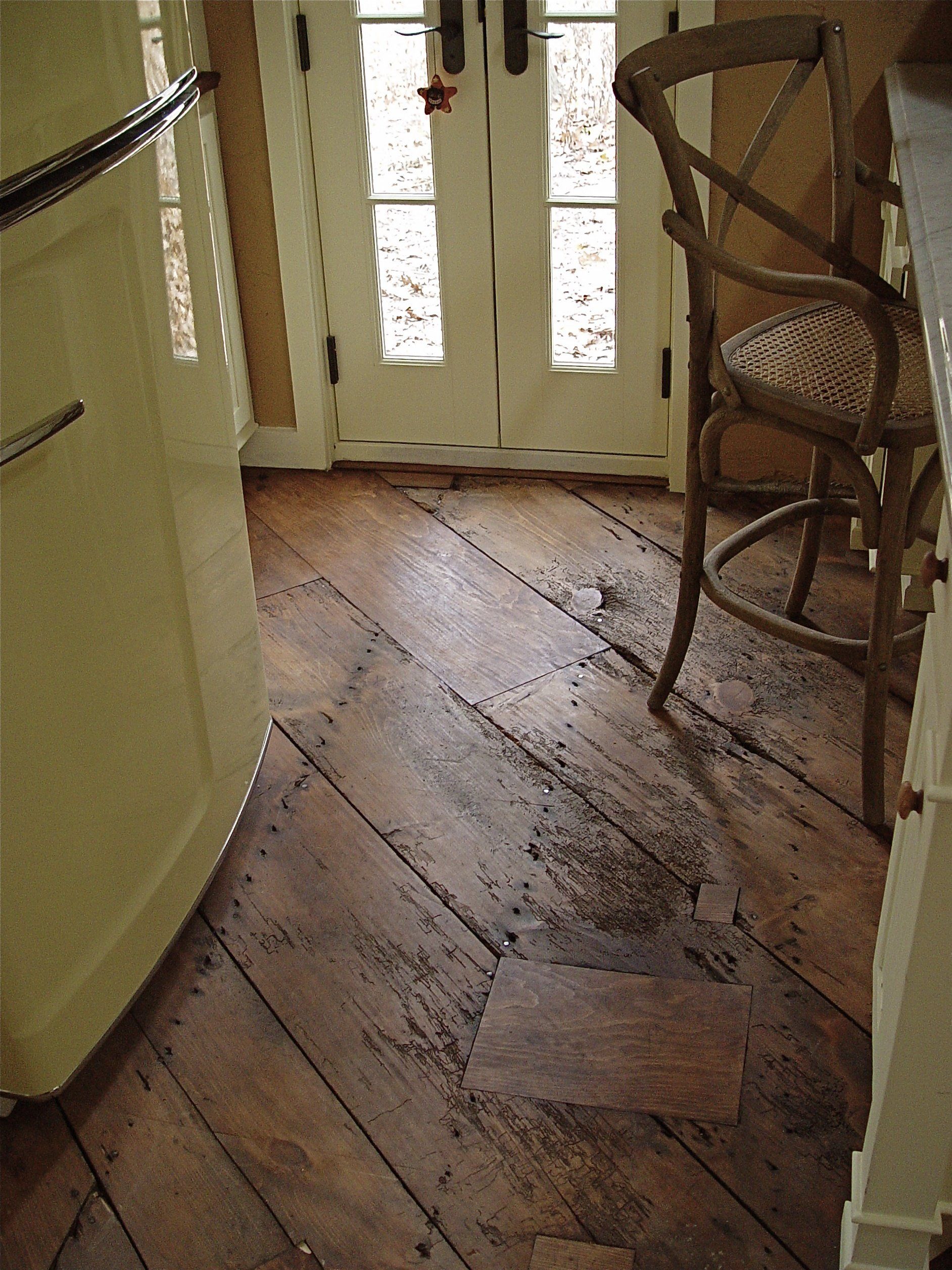 Wooden floorboards leading to white double doors, chair on the right, light-colored walls.