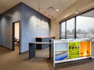 Reception area of an office featuring a reception desk and a blue accent wall.