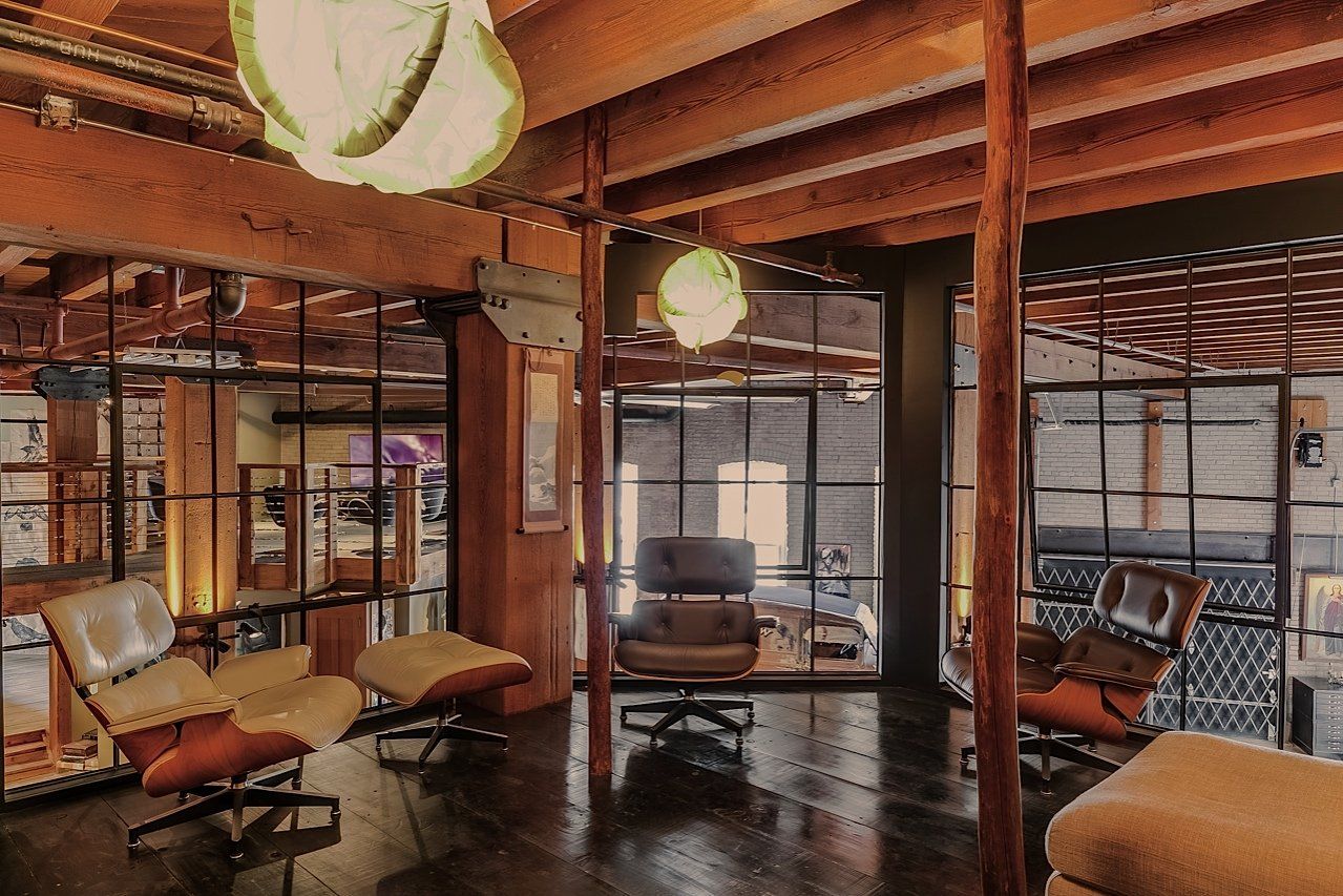 Interior with wood beams, glass walls, and mid-century modern furniture.