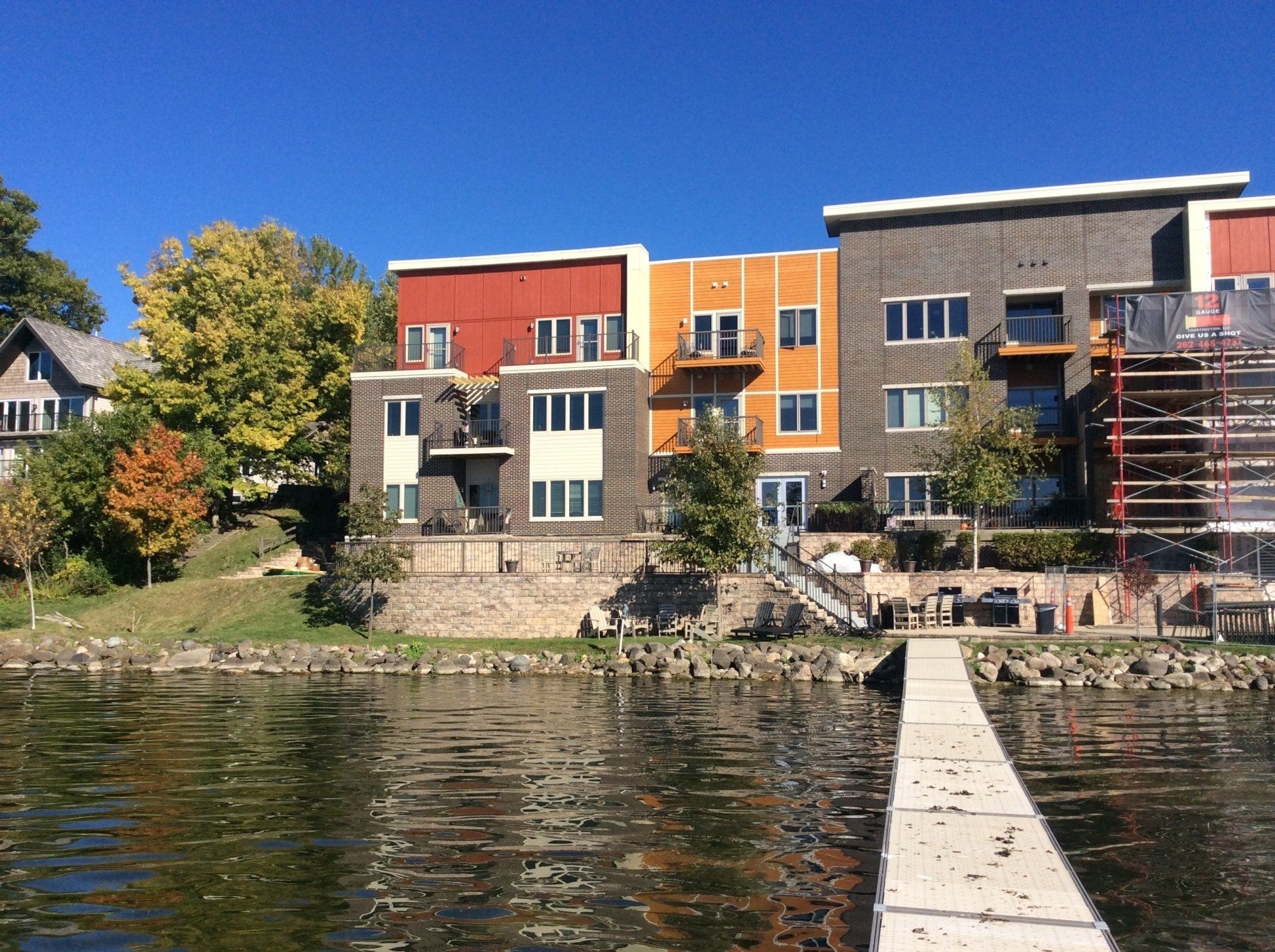 Colorful waterfront townhouses with a dock on a sunny day.