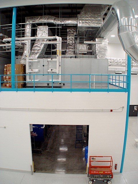 Large HVAC system on a raised platform, with ductwork. A doorway is below.