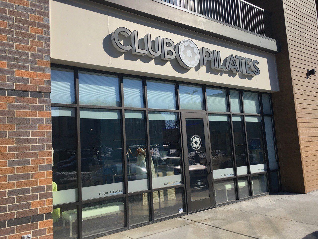 Club Pilates storefront with large windows and a dark door under a sign.
