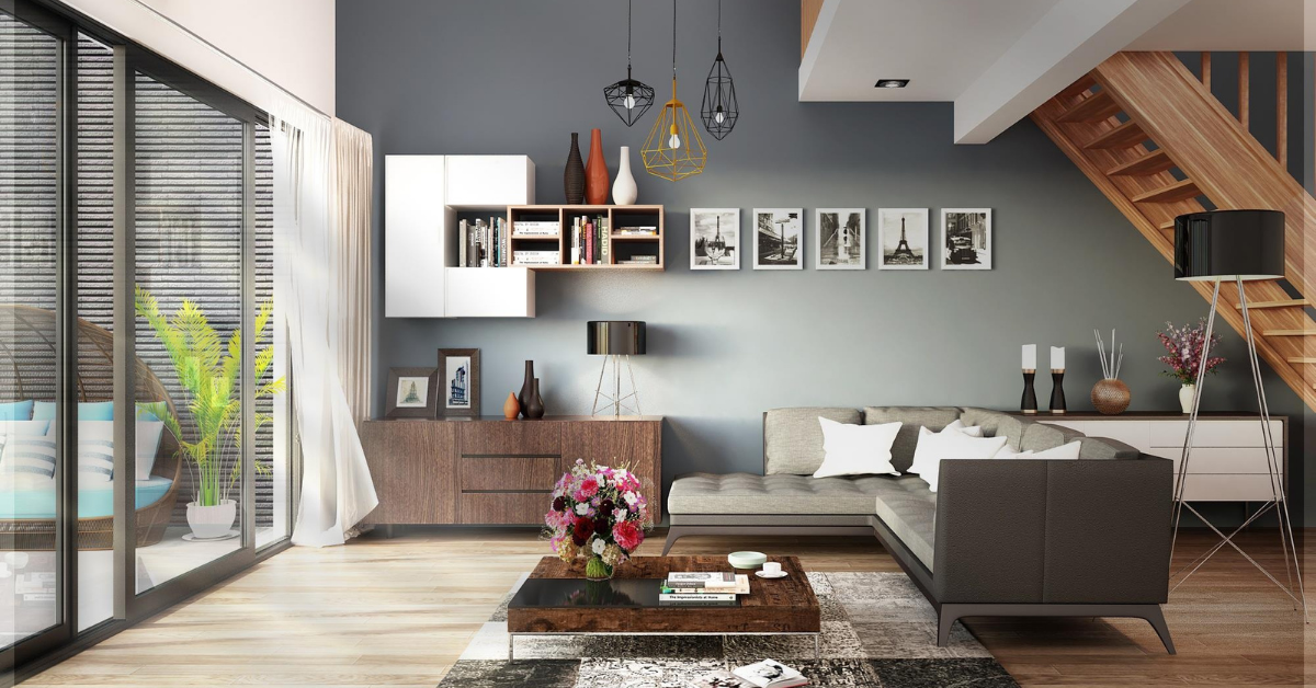Modern living room with sectional sofa, wooden staircase, and large windows.