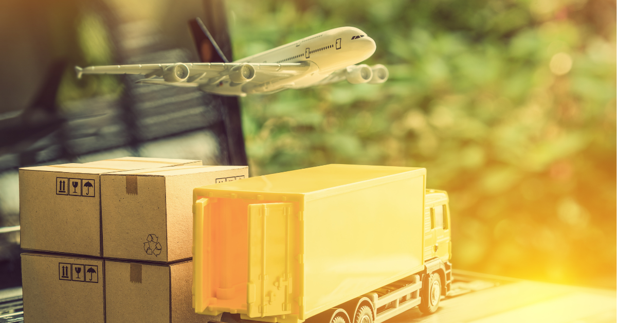 Model airplane, delivery truck, and cardboard boxes with an airplane flying in the background.