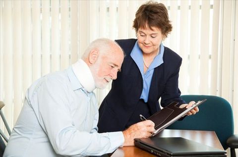 An elderly person signing a document