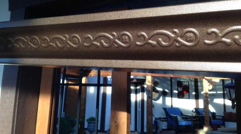Decorative carved wooden beam above a storefront window with reflections inside