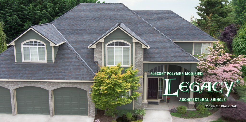 Large gray two-story suburban house with three-car garage and front porch