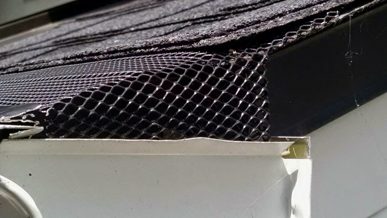 Black mesh fabric tucked under a dark surface on top of a white box edge