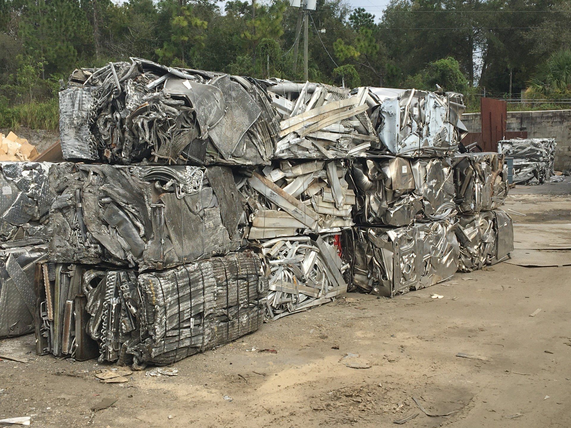 A pile of scrap metal is stacked on top of each other in a yard.