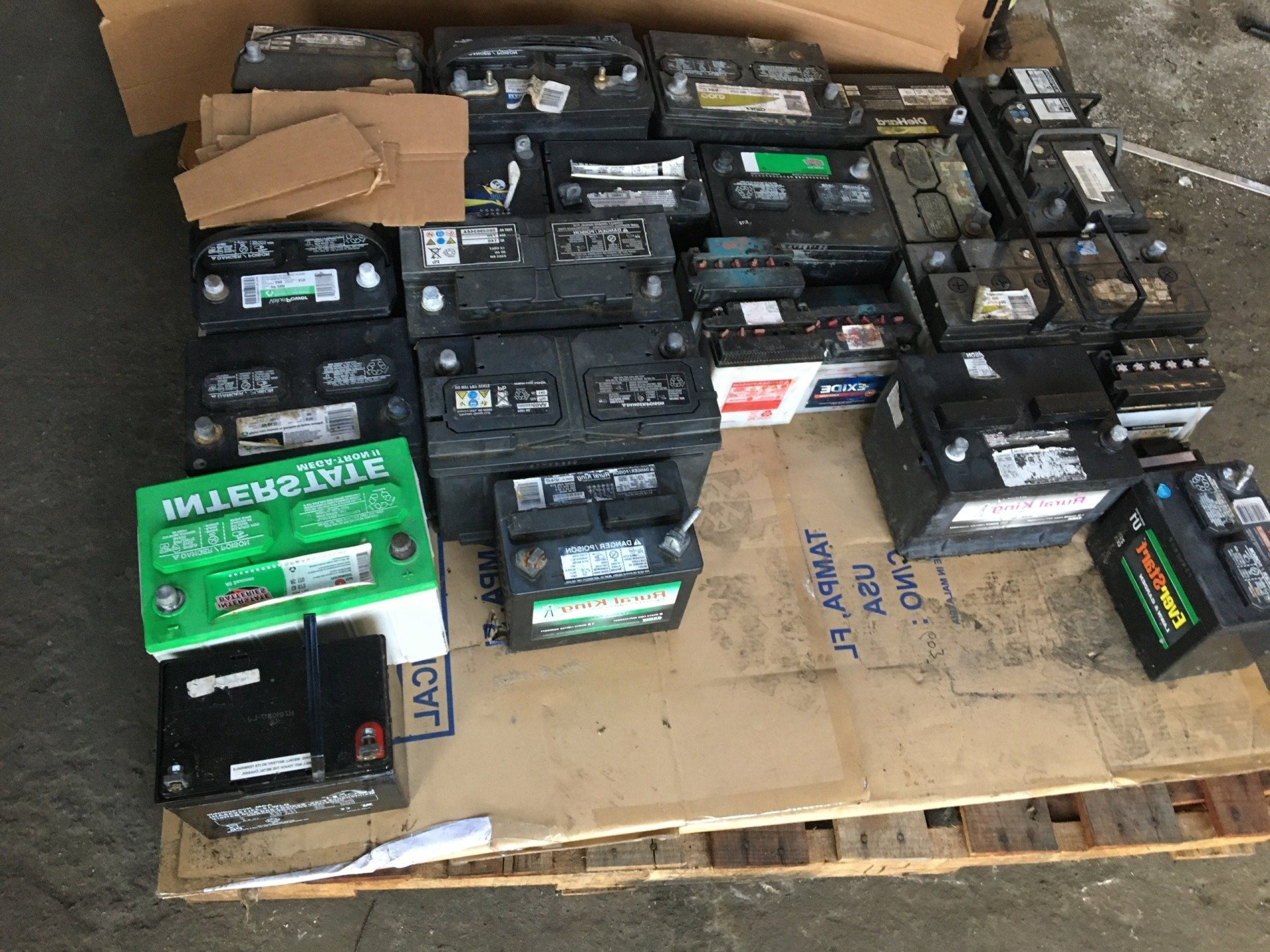 A pile of batteries sitting on top of a wooden pallet