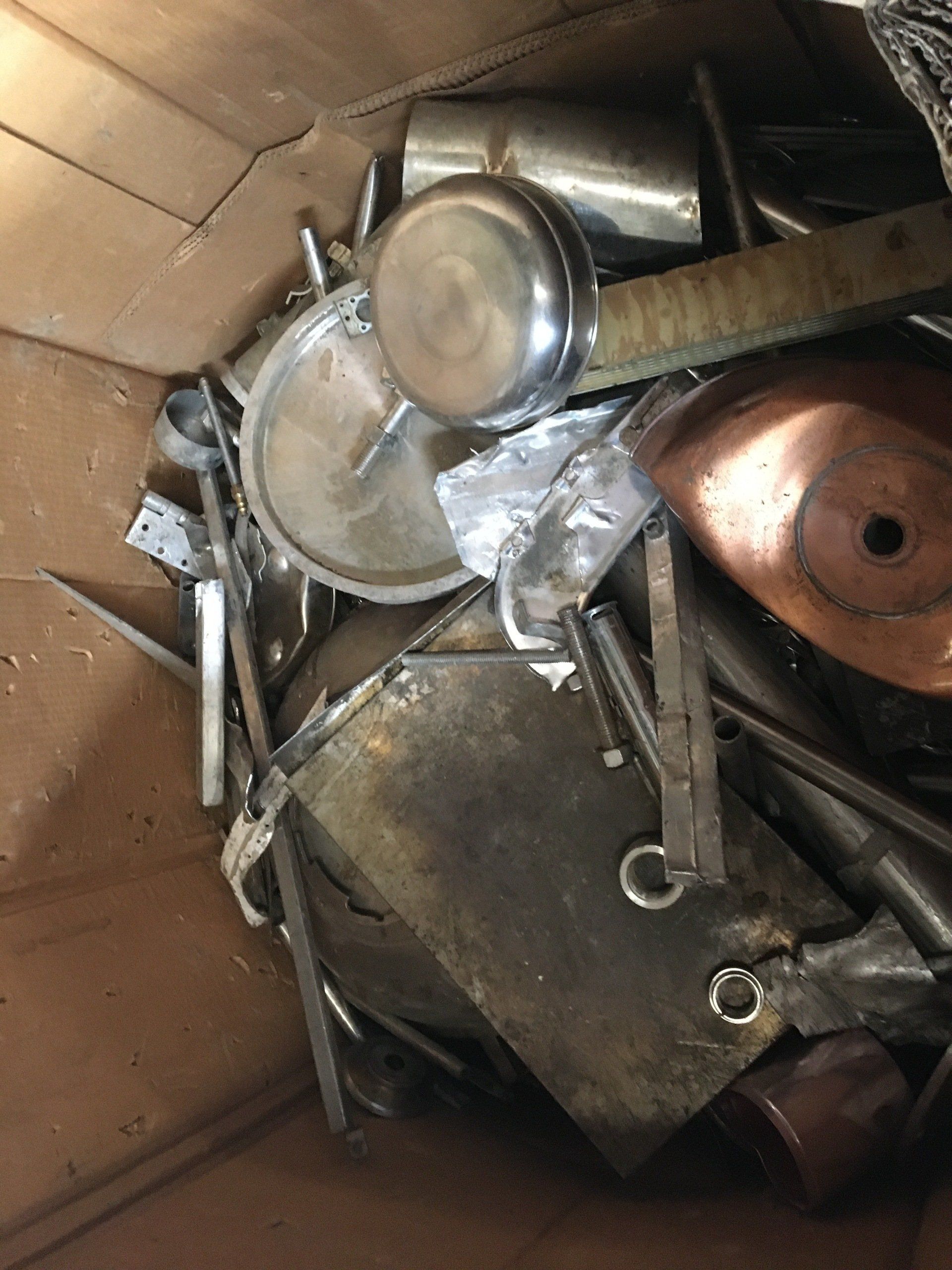 A pile of metal scraps in a cardboard box.