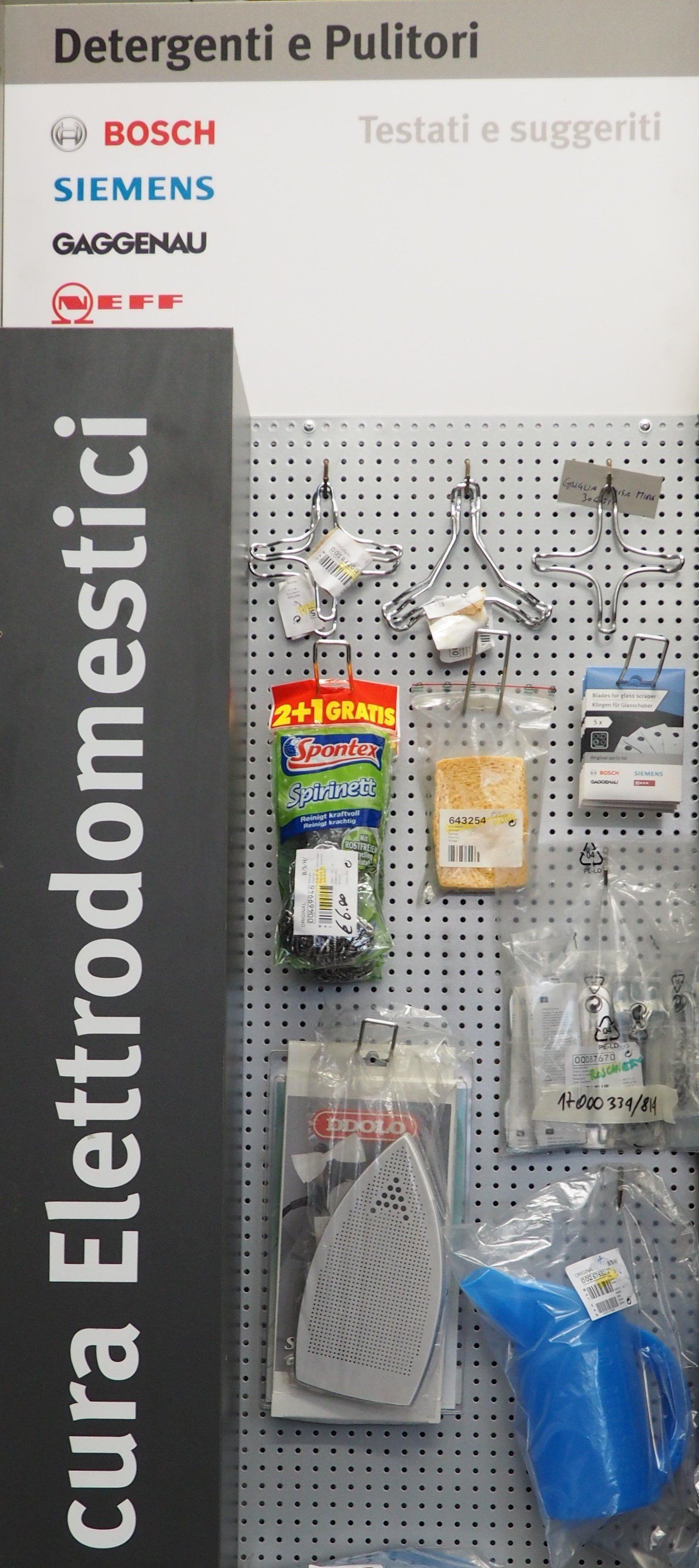 Esposizione in negozio di accessori per elettrodomestici per la pulizia Bosch, Siemens e di altre marche, su un espositore a pannello forato.