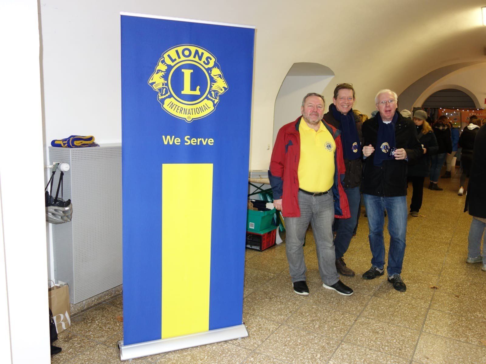 Eine Gruppe von Männern steht vor einem Schild mit der Aufschrift „Löwen“