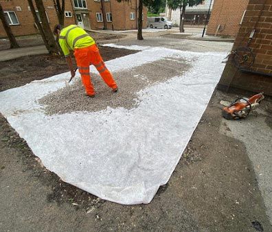 Workman spreading gravel