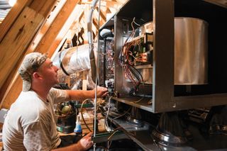 Heating Repair — Technician Turning the Heater On in Creve Coeur, IL