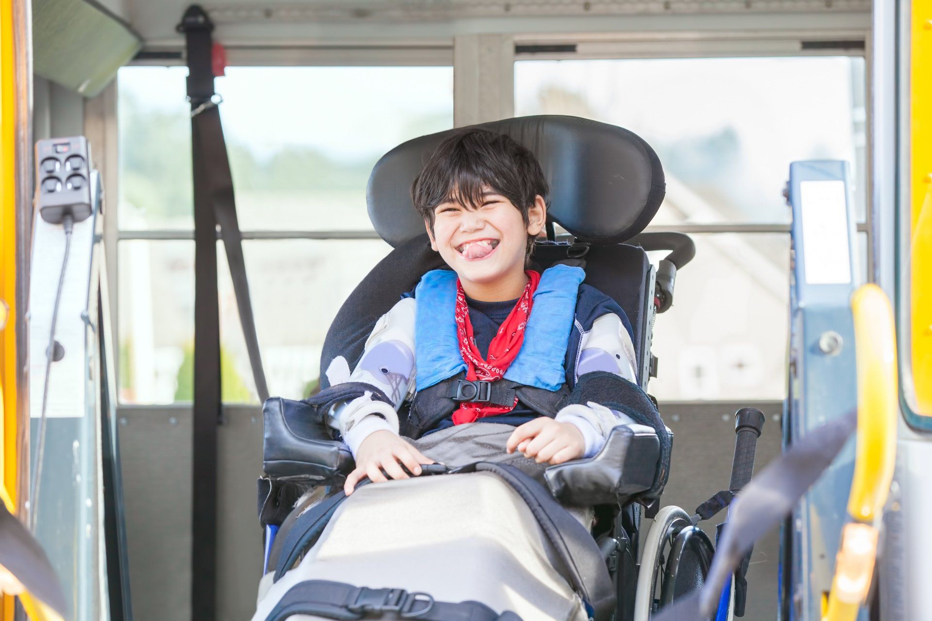 Child in wheelchair secured in accessible non-emergency medical transport vehicle
