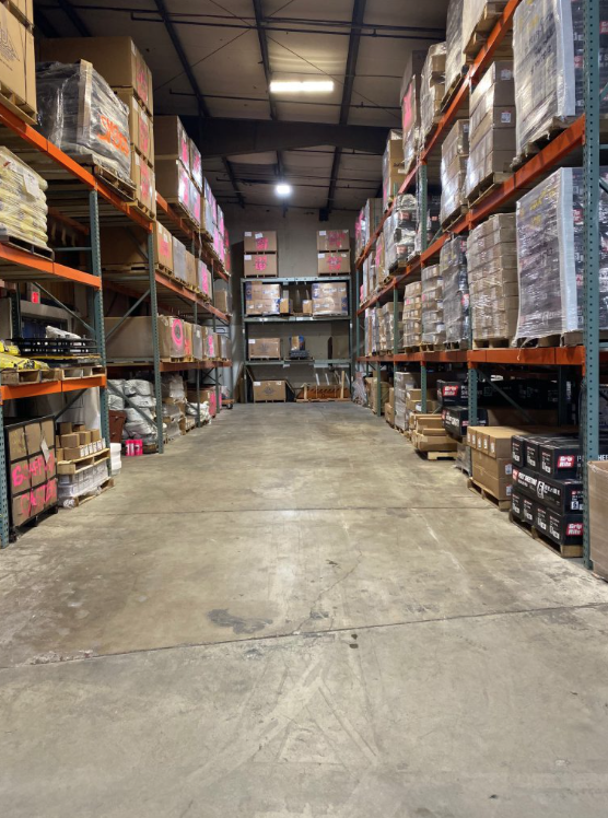 Warehouse aisle with pallet racking stocked with concrete and masonry supplies ready for contractor orders