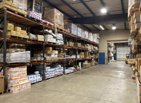 Warehouse aisle stocked with concrete and masonry materials organized on pallet racking for fast contractor pickup