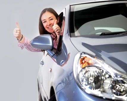 Girl with thumbs up leaning out of a window