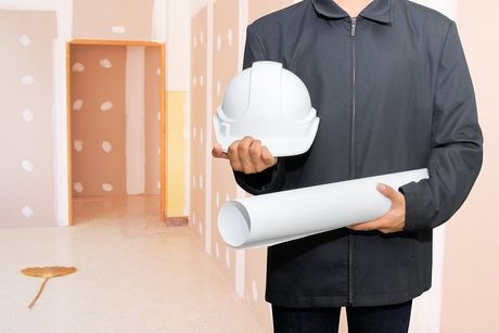 someone holding a hardhat and a blueprint