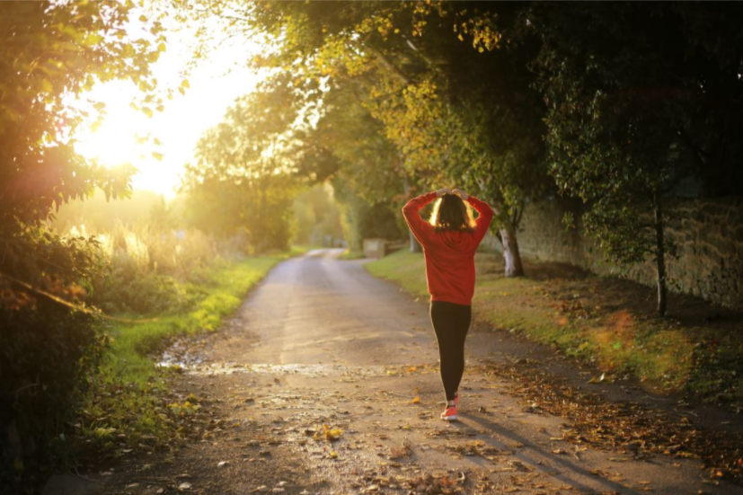person stretching on a path in sunlight