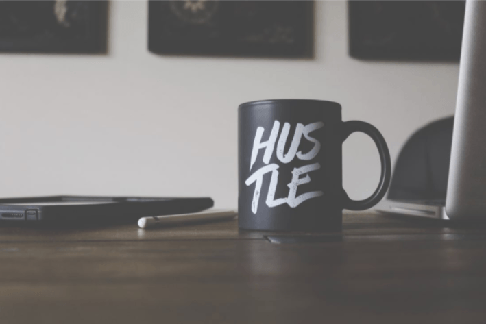 coffee mug with HUSTLE on it