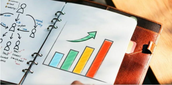 A person is holding a notebook with a graph on it
