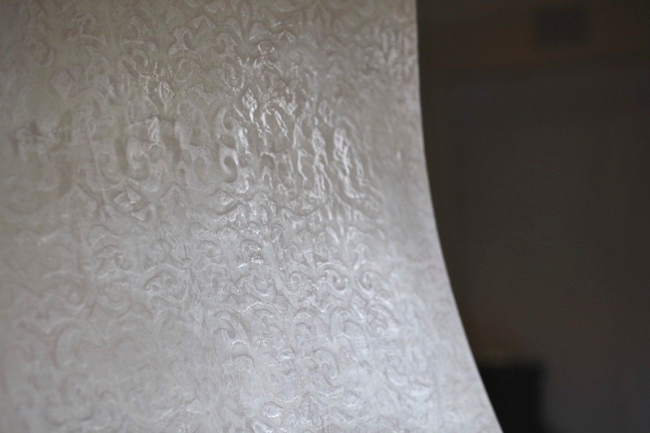 A close up of a lamp shade with a pattern on it.