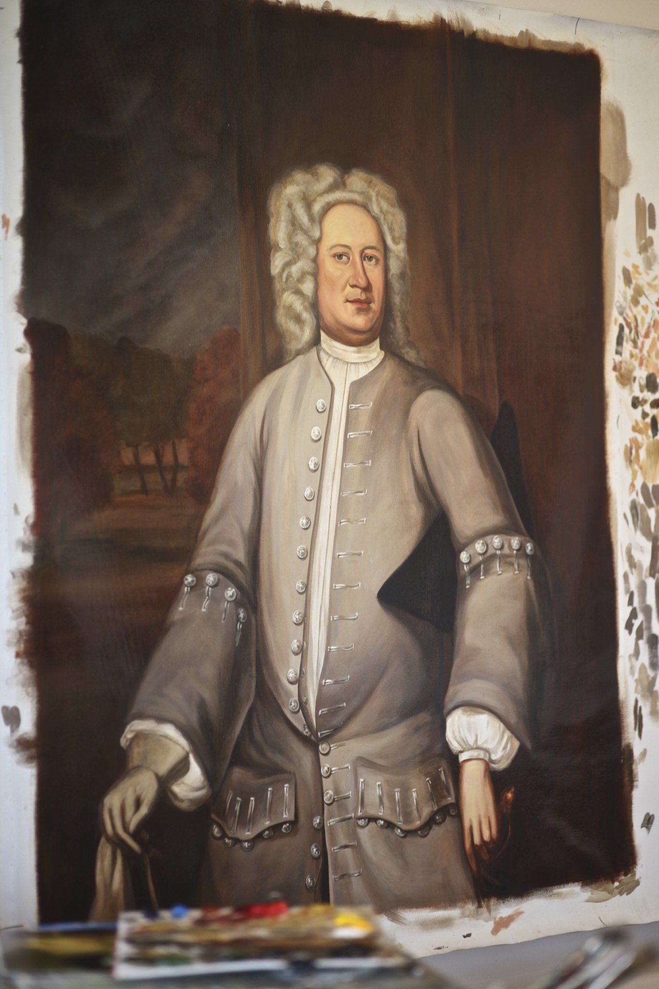 A painting of a man with curly hair is being painted