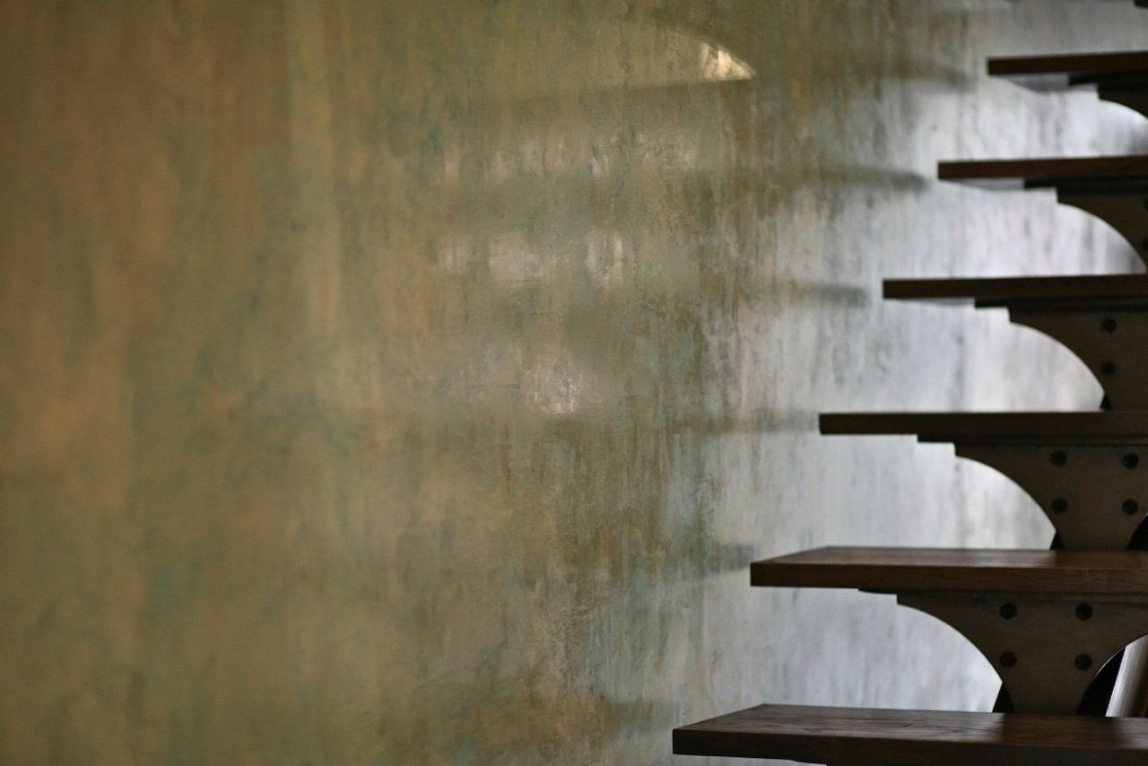 A staircase with a reflection of a wall in the background.