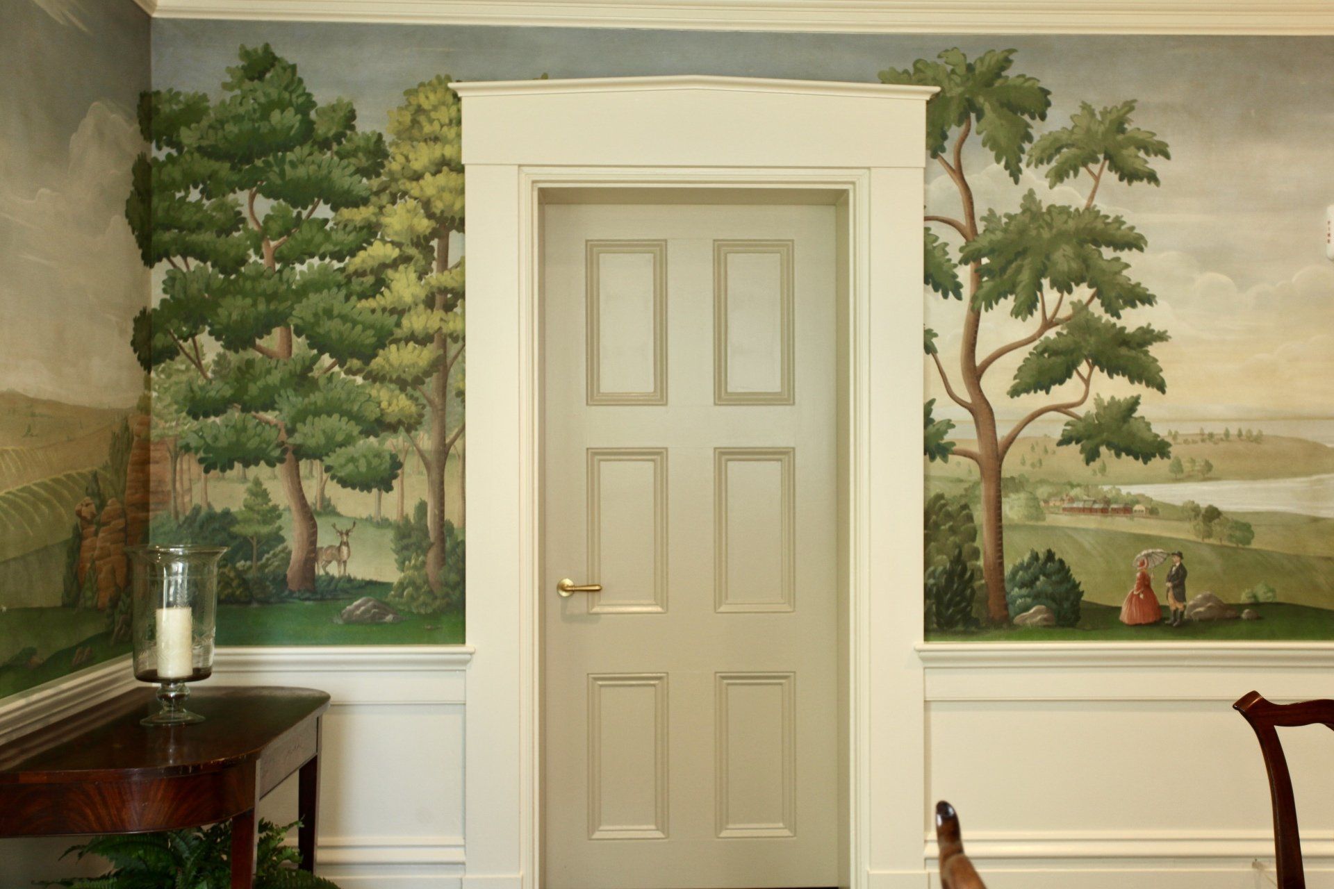 A door with a painting on the wall behind it