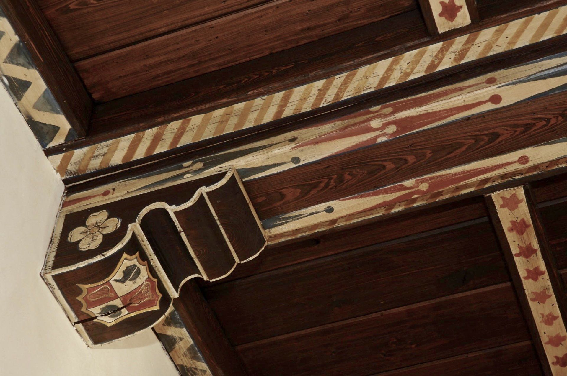 A wooden beam with a coat of arms on it