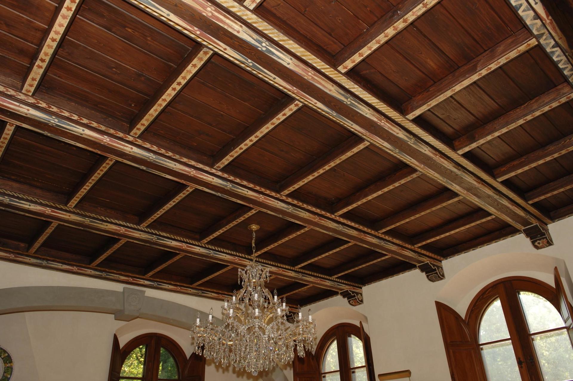 A wooden ceiling with a chandelier hanging from it