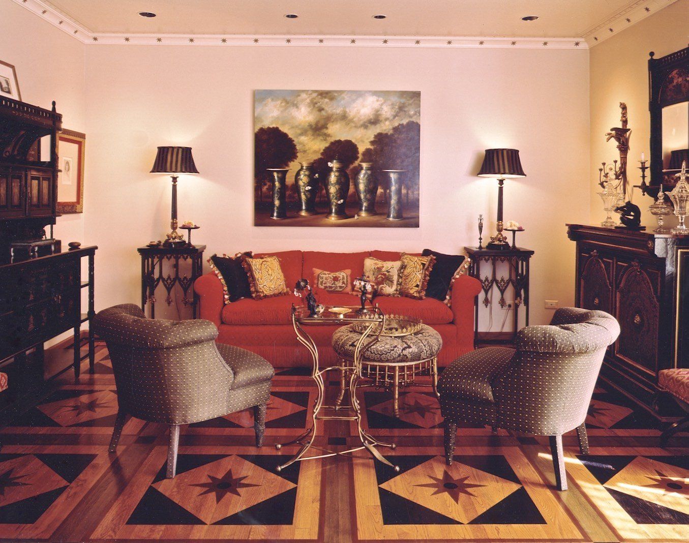 A living room with a red couch and chairs