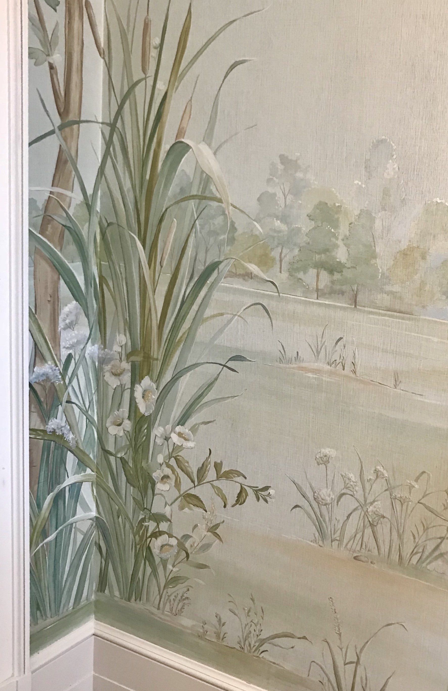 A corner of a wall with a painting of flowers and trees on it.