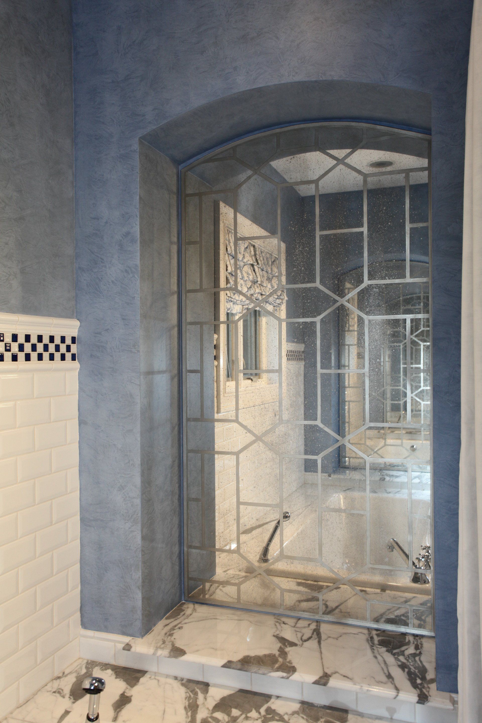 A bathroom with a stained glass shower door