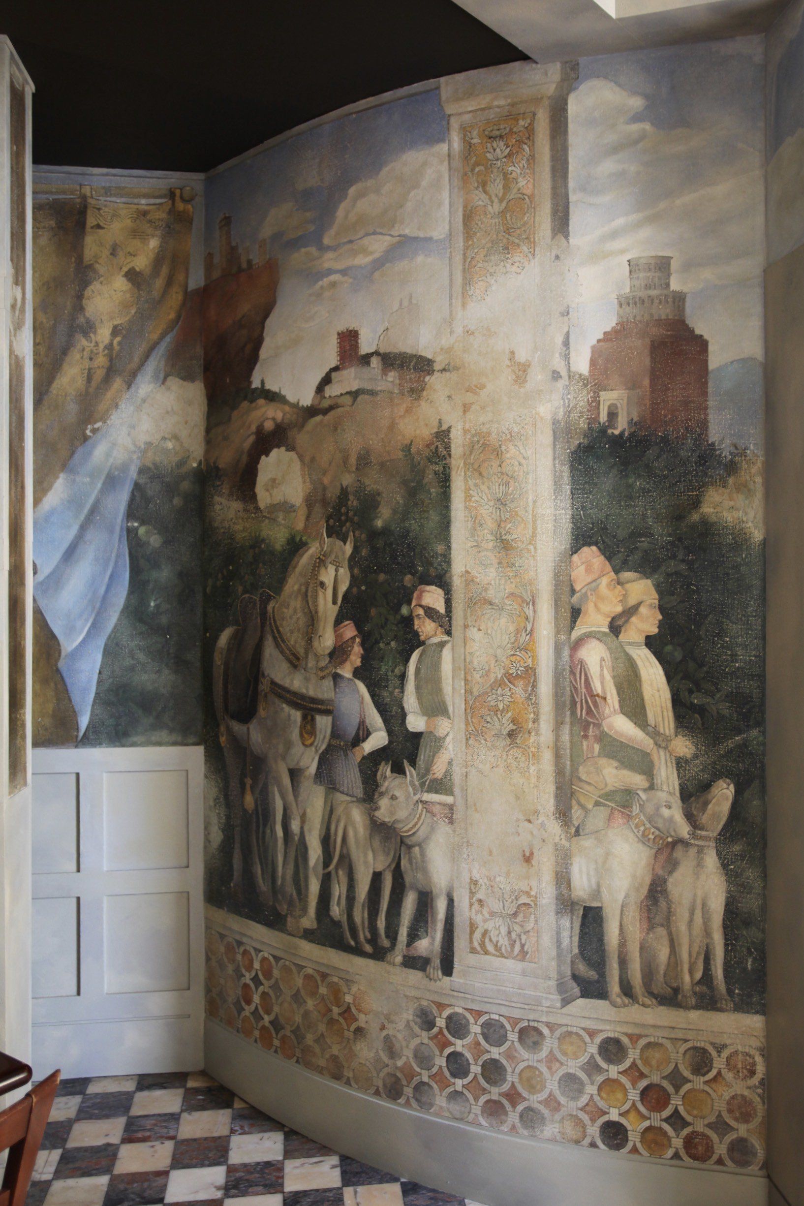 There is a painting on the wall of a room with a checkered floor.